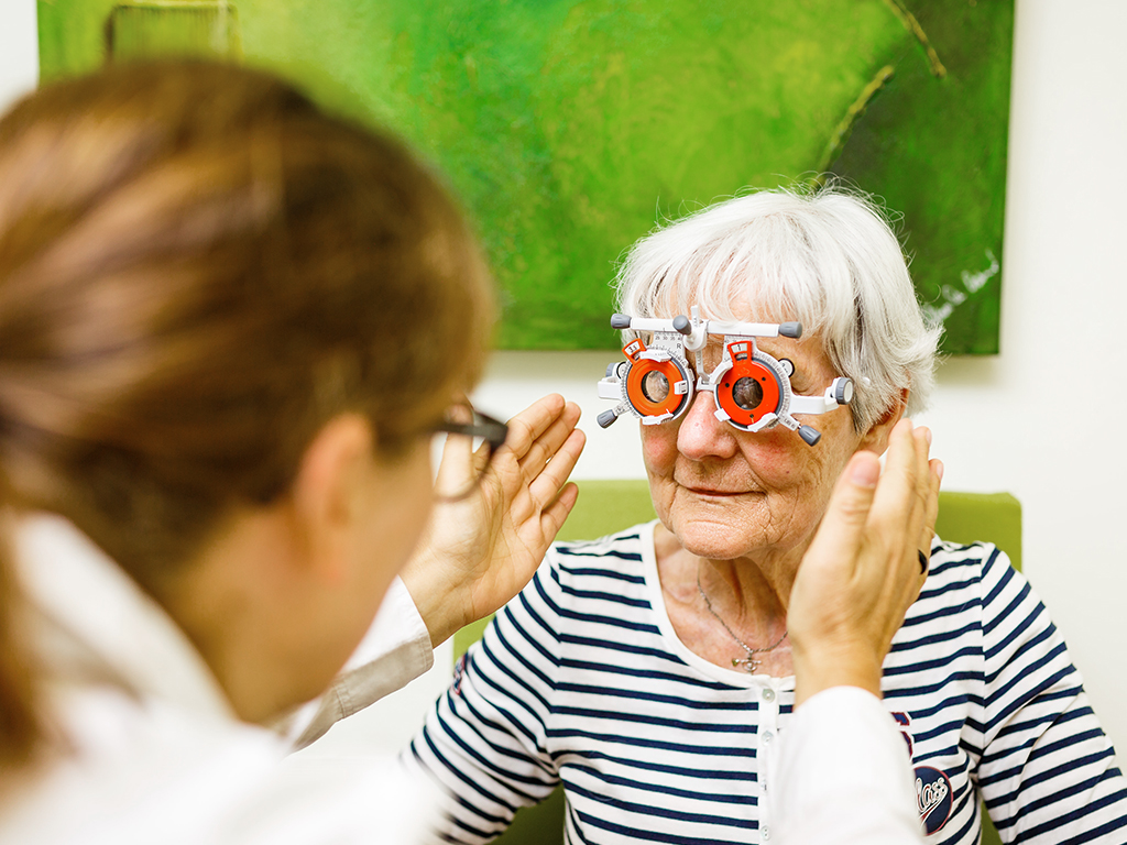 Frau mit einer Testbrille mit der die Sehkraft überprüft werden kann